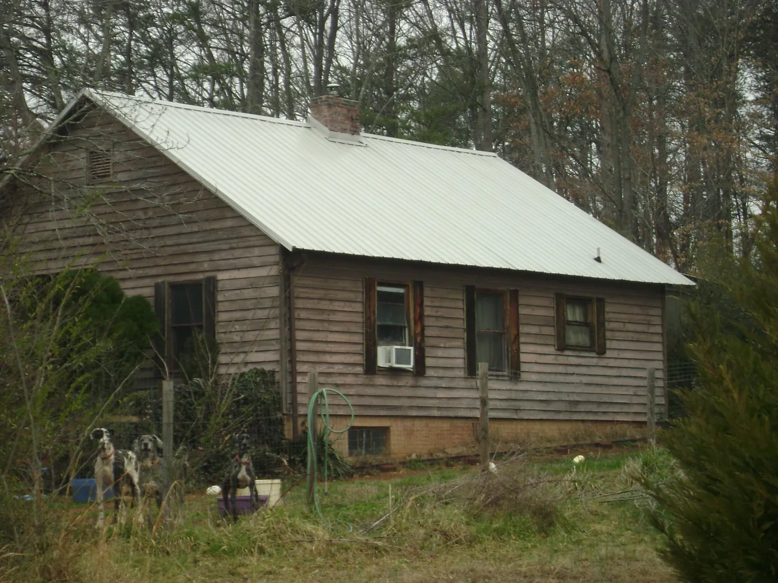 White metal roof on an old wood sided farmhouse, from a Metal Roof Installation job in Charles City